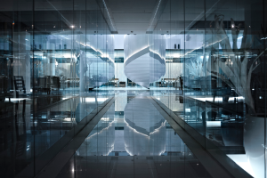 Das Innere eines Gebäudes mit Stühlen, Lampen und Glastüren mit einem sichtbaren Boden im Bild.