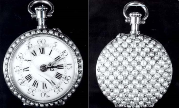 Eine silberne Taschenuhr mit Diamanten, die in ein rundes Zifferblatt mit römischen Zahlen eingelassen sind, auf schwarzem Hintergrund.