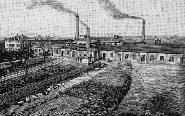 Schwarze und weiße Zeichnung einer Fabrik mit Rauch aus Schornsteinen, umgeben von Gebäuden, Bäumen, Pflanzen, Pfählen und Bahnschienen, beschriftet mit "1892 - die Fabrik des Eisenerzes" unten.