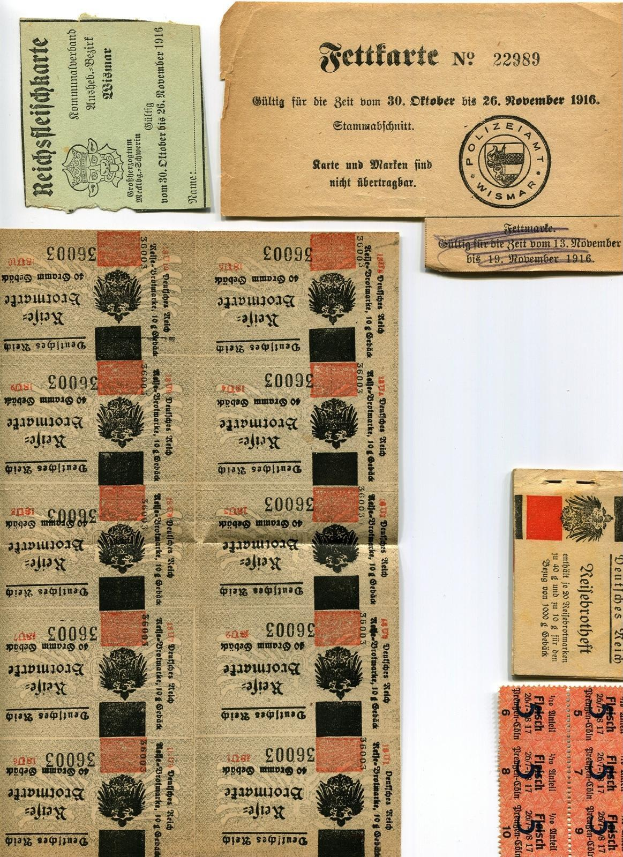 Sammlung alter deutscher Tickets und Marken auf einem weißen Hintergrund, die gedruckten Text und Zahlen anzeigen.