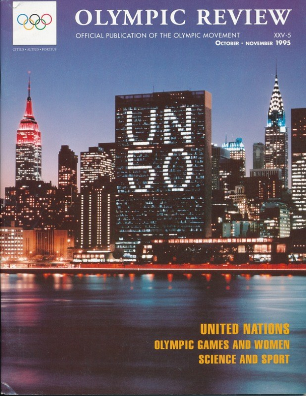 Buch mit dem Titel "Olympische Spiele-Rezension Offizielle Publikation der Olympischen Bewegung" mit einer Stadtansicht auf dem Cover, das auf einer flachen Oberfläche liegt.