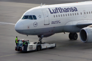 Eine Lufthansa Airbus A319-100 steht auf dem Rollfeld am Frankfurter Airport, mit einem Fahrzeug und einer Person in der Nähe, bereit zum Start.