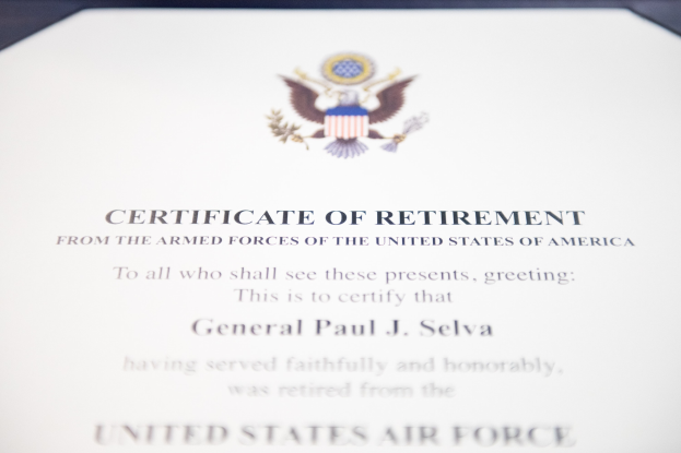Ein gerahmtes Ruhestandszertifikat der US-Luftwaffe mit blauem Rand, das ein Schild-Logo mit einem zentralen Stern, einem Lorbeerkranz und einer schwarzen 'Ruhestand'-Bannerschrift zeigt.