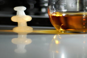 Ein Weinglas und ein weißer Schachstein sind auf einem Tisch plaziert.