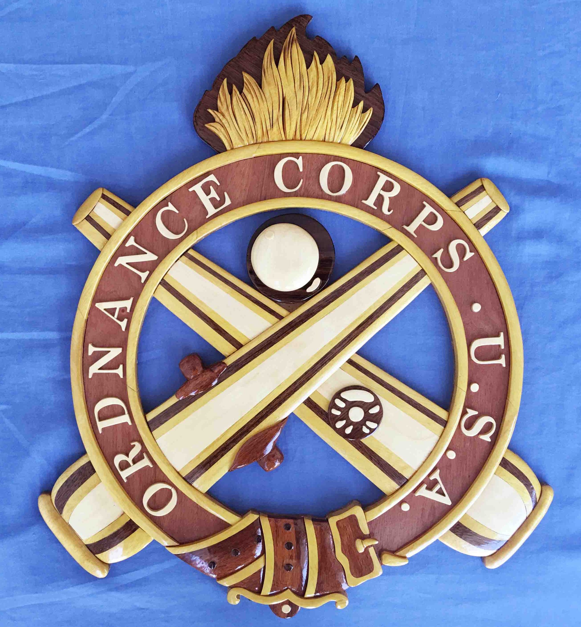 Holzschild mit "Ordnance Corps"-Text, zeigt ein geschnitztes weißes Stern auf marineblauem Hintergrund mit goldener Umrandung, auf blauem Tuch montiert.