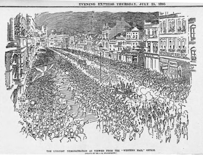 Schwarze und weiße Zeichnung einer Menge, die eine von Gebäuden gesäumte Straße entlanggeht, mit Text oben und unten: "Die Unionistendemonstration, wie sie vom Western Mail Office aus gesehen wird."