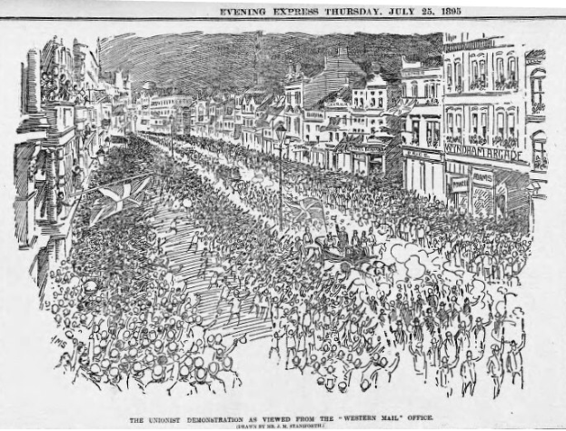 Schwarze und weiße Zeichnung einer Menge, die eine von Gebäuden gesäumte Straße entlanggeht, mit Text oben und unten: "Die Unionistendemonstration, wie sie vom Western Mail Office aus gesehen wird."