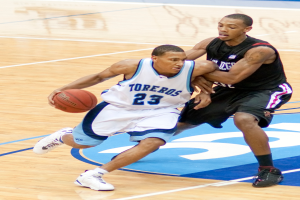 Zwei Personen spielen Basketball, wobei eine Person den Ball hält.