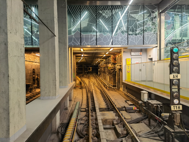 Ein Bahnhof mit einem Zug auf den Schienen, beleuchtet von Oberlichtern, mit einer Plattform und Säulen auf der linken Seite und einem Signal mit einem Mast auf der rechten Seite, Teil der kürzlich wiedereröffneten London Underground.