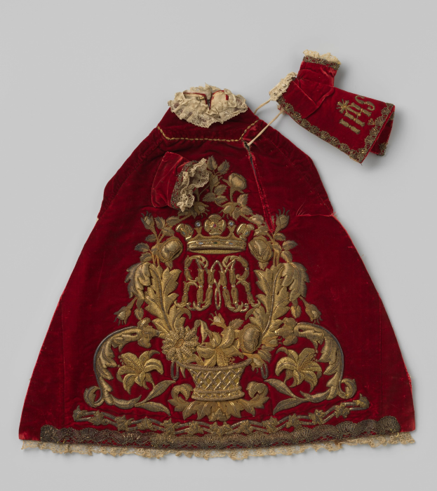 Ein roter Samtmantel mit goldener Stickerei und einer Krone auf einem weißen Hintergrund, verziert mit detaillierten königlichen Designs.