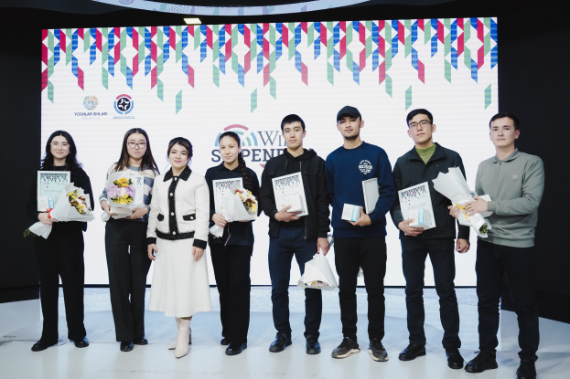 Eine Gruppe von Menschen auf einer Bühne mit Bücher und Blumensträußen, im Hintergrund ein Bildschirm mit der Aufschrift "Yogyakarta International School of Science and Technology"