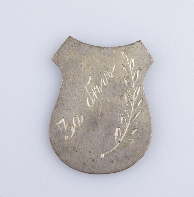 Silberne Anstecknadel mit Lorbeerkranz-Design, beschriftet mit "50-jähriges Jubiläum", auf weißem Hintergrund.