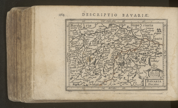 Ein altes Buch mit einer detaillierten Karte von Bayerns geografischen Merkmalen auf dem Cover, das vor einem schwarzen Hintergrund dargestellt wird.