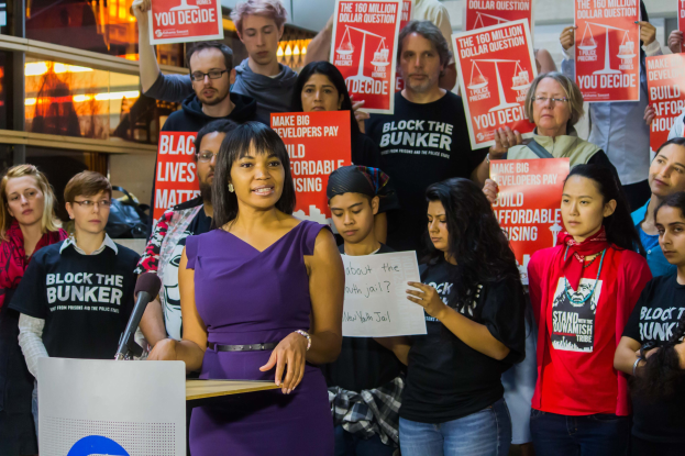 Eine Black Lives Matter-Aktivistin spricht vor einem Publikum mit Mikrofon an einem Rednerpult.