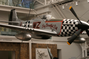 Ein mit Kabeln gesichertes Flugzeug in einem Gebäude, mit Polizei-Lichtern und Stühlen im Hintergrund.