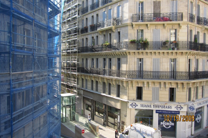 Ein gro├čer Bau auf der linken Seite, mit einem Laden auf der rechten Seite.